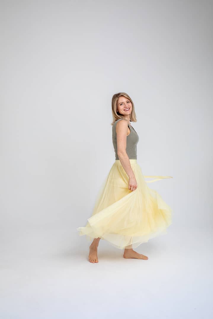 a woman in a yellow skirt and an olive green top